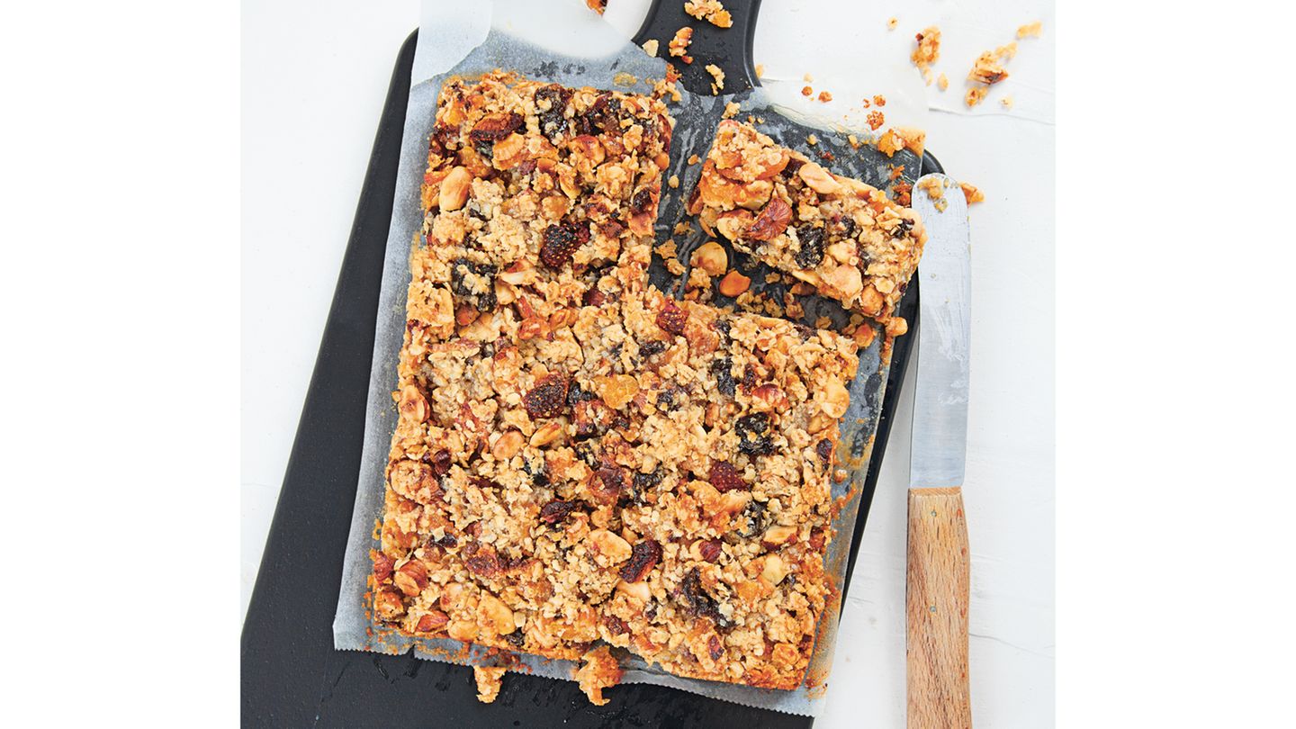Bewusst essen: Müsliriegel Zutaten: 125 g blanchierte Mandelkerne, 125 g Haselnusskerne, 100 g Soft-Aprikosen, 75 g Soft-Pflaumen, 10 g gefriergetrocknete Erdbeeren, 200 g vegane Margarine, 100 g Kokosmus, 75 g Mandelmus, 150 g cremige Kokosmilch, 100 g flüssiger Honig, 200 g zarte Haferflocken, 2 TL Chiasamen-Mehl (optional) Außerdem: Backpapier Zubereitung: Die Mandeln und die Haselnüsse grob hacken, in einer Pfanne ohne Fett rösten, bis die Kerne beginnen zu duften, beides herausnehmen und auskühlen lassen. Die Aprikosen und die Pflaumen fein hacken. Die Erdbeeren grob hacken. Den Backofen auf 175 °C (Ober-/Unterhitze) vorheizen. Die Margarine, das Kokosmus, das Mandelmus, die Kokosmilch und den Honig in einem Topf erhitzen. Die Kerne, die getrockneten Früchte, die Haferflocken, die Erdbeeren und evtl. das Chiasamen-Mehl einrühren. Den Riegelteig in eine mit Backpapier ausgelegte quadratische Springform (etwa 24 x 24 cm) füllen, glattstreichen, gut andrücken und im Backofen 25–30 Minuten backen. Den gebackenen Riegelteig herausnehmen, auskühlen lassen, in etwa 20 Müsliriegel schneiden und servieren. Mehr Rezepte finden Sie in in: Sporternährung für jeden Tag, 240 Seiten, 29,99 Euro Müsliriegel Zutaten: 125 g blanchierte Mandelkerne, 125 g Haselnusskerne, 100 g Soft-Aprikosen, 75 g Soft-Pflaumen, 10 g gefriergetrocknete Erdbeeren, 200 g vegane Margarine, 100 g Kokosmus, 75 g Mandelmus, 150 g cremige Kokosmilch, 100 g flüssiger Honig, 200 g zarte Haferflocken, 2 TL Chiasamen-Mehl (optional) Außerdem: Backpapier Zubereitung: Die Mandeln und die Haselnüsse grob hacken, in einer Pfanne ohne Fett rösten, bis die Kerne beginnen zu duften, beides herausnehmen und auskühlen lassen. Die Aprikosen und die Pflaumen fein hacken. Die Erdbeeren grob hacken. Den Backofen auf 175 °C (Ober-/Unterhitze) vorheizen. Die Margarine, das Kokosmus, das Mandelmus, die Kokosmilch und den Honig in einem Topf erhitzen. Die Kerne, die getrockneten Früchte, die Haferflocken, die Erdbeeren und evtl. das Chiasamen-Mehl einrühren. Den Riegelteig in eine mit Backpapier ausgelegte quadratische Springform (etwa 24 x 24 cm) füllen, glattstreichen, gut andrücken und im Backofen 25–30 Minuten backen. Den gebackenen Riegelteig herausnehmen, auskühlen lassen, in etwa 20 Müsliriegel schneiden und servieren. Mehr Rezepte finden Sie in in: Sporternährung für jeden Tag, 240 Seiten, 29,99 Euro