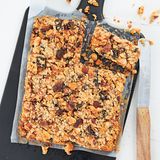 Müsliriegel      Zutaten:  125 g blanchierte Mandelkerne, 125 g Haselnusskerne, 100 g Soft-Aprikosen, 75 g Soft-Pflaumen, 10 g gefriergetrocknete Erdbeeren, 200 g vegane Margarine, 100 g Kokosmus, 75 g Mandelmus, 150 g cremige Kokosmilch, 100 g flüssiger Honig, 200 g zarte Haferflocken, 2 TL Chiasamen-Mehl (optional)  Außerdem: Backpapier      Zubereitung:  Die Mandeln und die Haselnüsse grob hacken, in einer Pfanne ohne Fett rösten, bis die Kerne beginnen zu duften, beides herausnehmen und auskühlen lassen. Die Aprikosen und die Pflaumen fein hacken. Die Erdbeeren grob hacken. Den Backofen auf 175 °C (Ober-/Unterhitze) vorheizen. Die Margarine, das Kokosmus, das Mandelmus, die Kokosmilch und den Honig in einem Topf erhitzen. Die Kerne, die getrockneten Früchte, die Haferflocken, die Erdbeeren und evtl. das Chiasamen-Mehl einrühren. Den Riegelteig in eine mit Backpapier ausgelegte quadratische Springform (etwa 24 x 24 cm) füllen, glattstreichen, gut andrücken und im Backofen 25–30 Minuten backen. Den gebackenen Riegelteig herausnehmen, auskühlen lassen, in etwa 20 Müsliriegel schneiden und servieren.      Mehr Rezepte finden Sie in in: Sporternährung für jeden Tag, 240 Seiten, 29,99 Euro