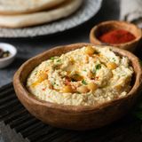 Hummus      Zutaten:  1 Dose Kichererbsen, 4 EL Tahin, 2 Knoblauchzehen, 4 EL Olivenöl, Saft von 1 Zitrone, Salz, Pfeffer, ggf. 1 TL Kreuzkümmel und Chilipulver      Zubereitung:  Kichererbsen abtopfen lassen und mit einem Pürierstab anpürieren. Tahini, Olivenöl, Zitronensaft sowie geschälte Knoblauchzehen dazugeben. Alles fein pürieren. Salzen und Pfeffern. Wer mag schmeckt zusätzlich mit Kreuzkümmel und Chilipulver ab. Man reicht Hummus entweder zu Fladenbrot, die gesündere Optionen wären Gemüsesticks.