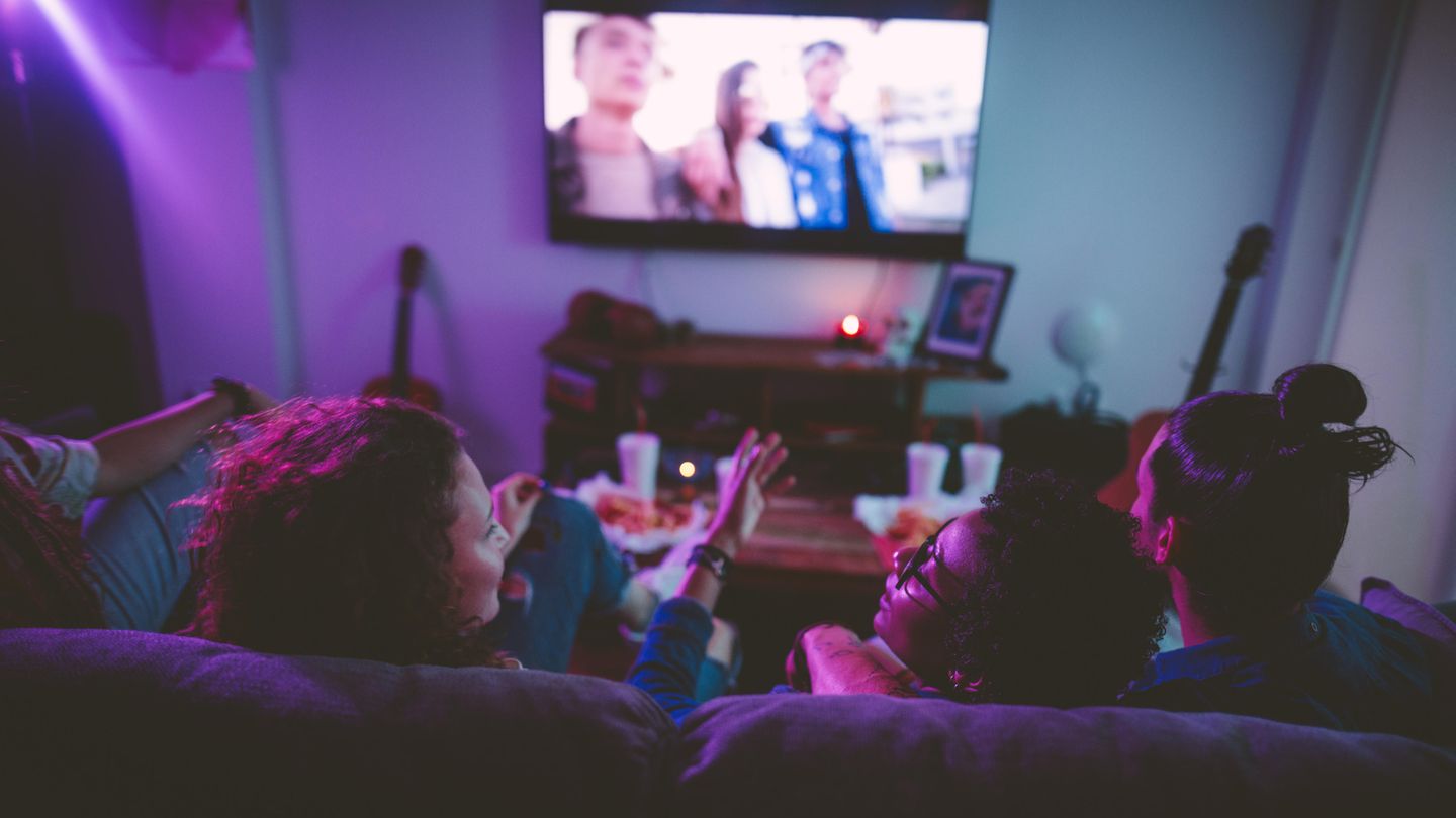 Menschen, die auf einem Sofa sitzen und einen Film sehen