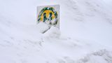 Die Bushaltestelle an einem Dorf am bayrischen Spitzingsee geht in den Schneemassen fast unter