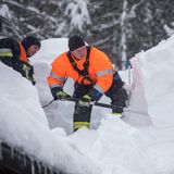  Bayern, Buchenhöhe. Feuerwehrmänner schaufeln Schnee vom Dach eines Hauses. Nach starkem Schneefall sitzen bei Berchtesgaden rund 350 Menschen fest und müssen per Lastwagen mit Lebensmitteln versorgt werden.