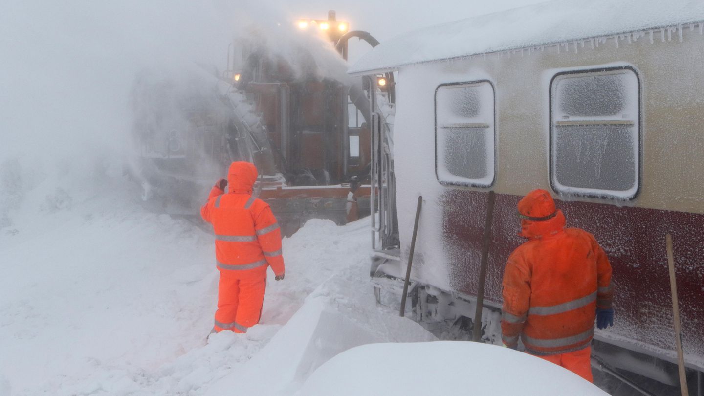 Sachsen-Anhalt, Schierke. Mitarbeiter der Servicegesellschaft versuchen einen Zug der Harzer Schmalspurbahn, der seit Montag auf dem Brocken eingeschneit ist, vom Schnee zu befreien.