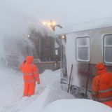 Sachsen-Anhalt, Schierke. Mitarbeiter der Servicegesellschaft versuchen einen Zug der Harzer Schmalspurbahn, der seit Montag auf dem Brocken eingeschneit ist, vom Schnee zu befreien.