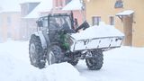 Sachsen, Geyer: Ein Radlader transportiert Schnee. Weitere Schneefälle werden erwartet