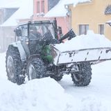 Sachsen, Geyer: Ein Radlader transportiert Schnee. Weitere Schneefälle werden erwartet