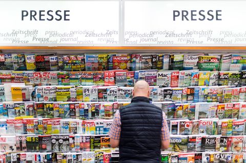 Ein Mann steht vor einem Zeitschriftenregal