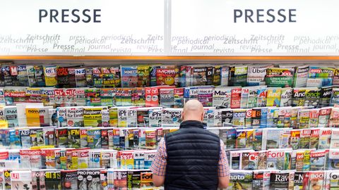Ein Mann steht vor einem Zeitschriftenregal