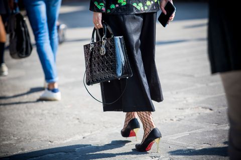 Frau in Culotte und High-Heels läuft über die Straße