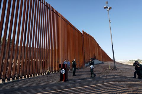 USA, Calexico: Grenzschutzbeamte stehen neben einem neuen Abschnitt der Grenzmauer zwischen den USA und Mexiko