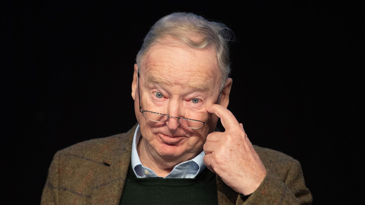 Alexander Gauland sitzt vor einem schwarzen Hintergrund und kratzt sich mit dem linken Zeigefinger im linken Augenwinkel