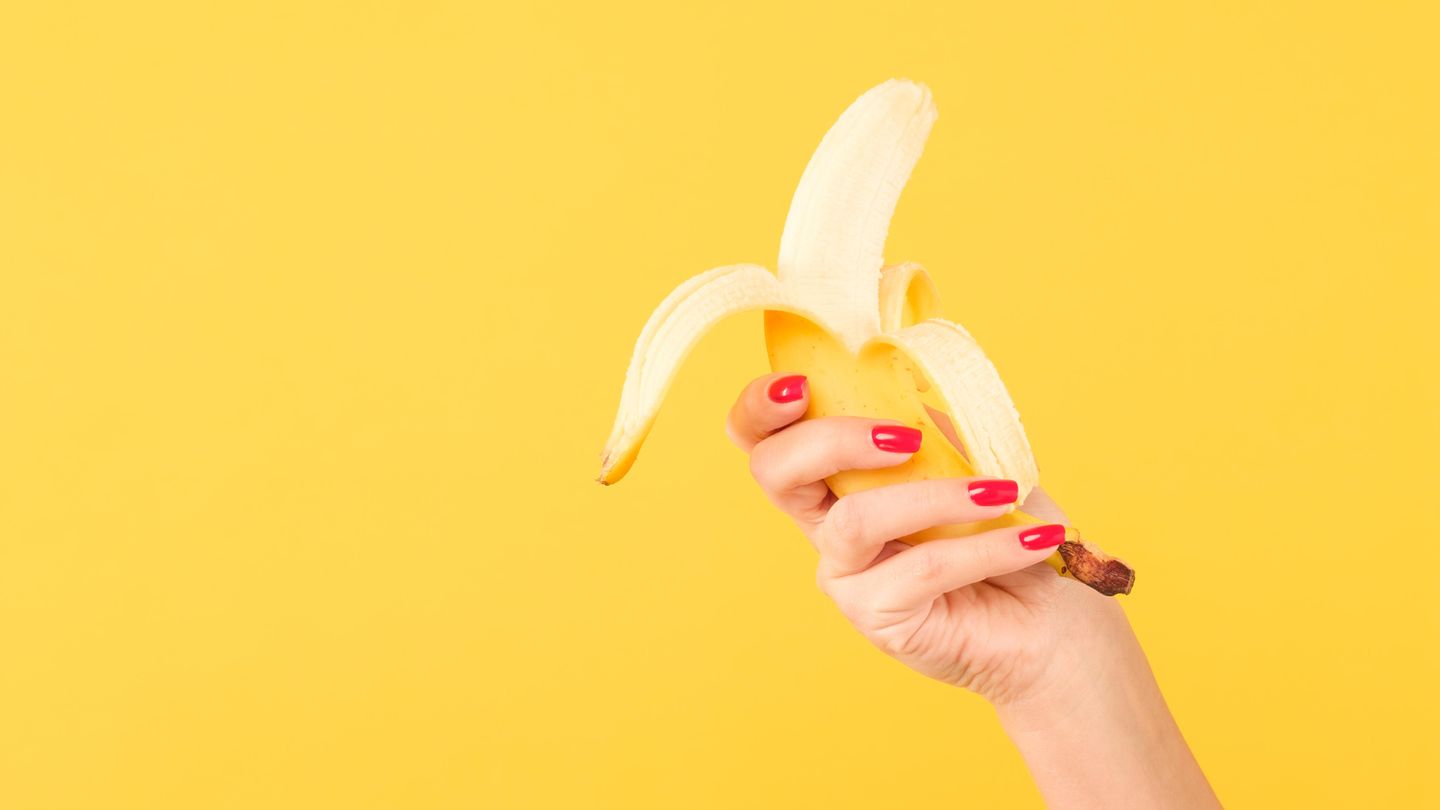 Nach dem Schälen bitte Hände waschen: Eine Frau hält eine Banane in der Hand
