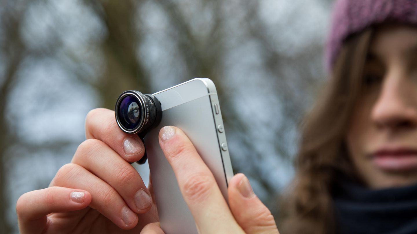 Eine junge Frau fotografiert mit ihrem Smartphone