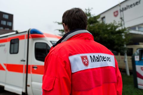 Ein Rettungssanitäter steht vor einem Rettungswagen