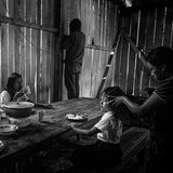 Häuptling Domingo empfängt am Handy Nachrichten zum Überfall auf das Minencamp am vorigen Tag, während seine Kinder frühstücken