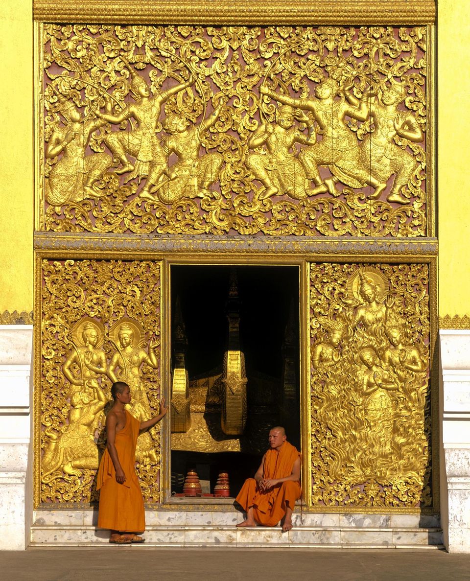 Luang Prabang: Mönche und goldene Reliefs am Eingang zum Carriage House, des Tempels Wat Xiengtong Mönche und goldene Reliefs am Eingang zum Carriage House, des Tempels Wat Xiengtong