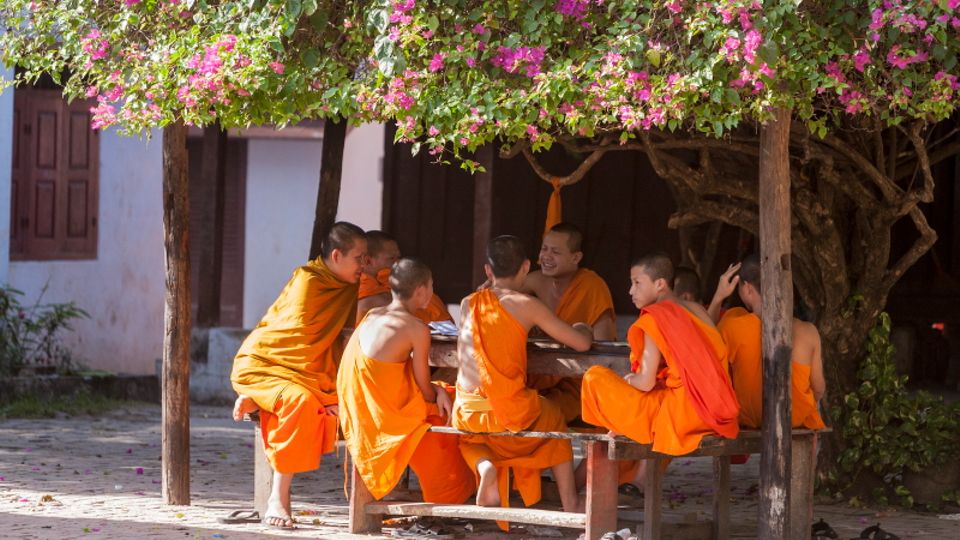 Luang Prabang: Zwischen Gebet, Arbeit und Meditation treffen sich Mönche im Hof des Wat Si Bun Heuang zu einem Plausch. Zwischen Gebet, Arbeit und Meditation treffen sich Mönche im Hof des Wat Si Bun Heuang zu einem Plausch.