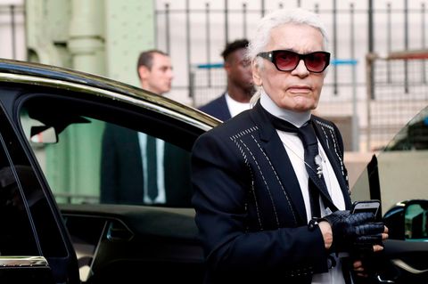 Karl Lagerfeld steigt im typischen Look mit Sonnenbrille und Handschuhen aus einer Limousine aus