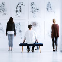Mann sitzt in Museum auf Bank