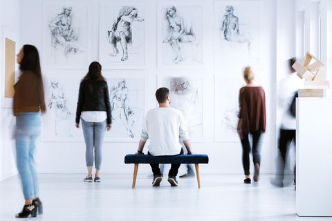 Mann sitzt in Museum auf Bank
