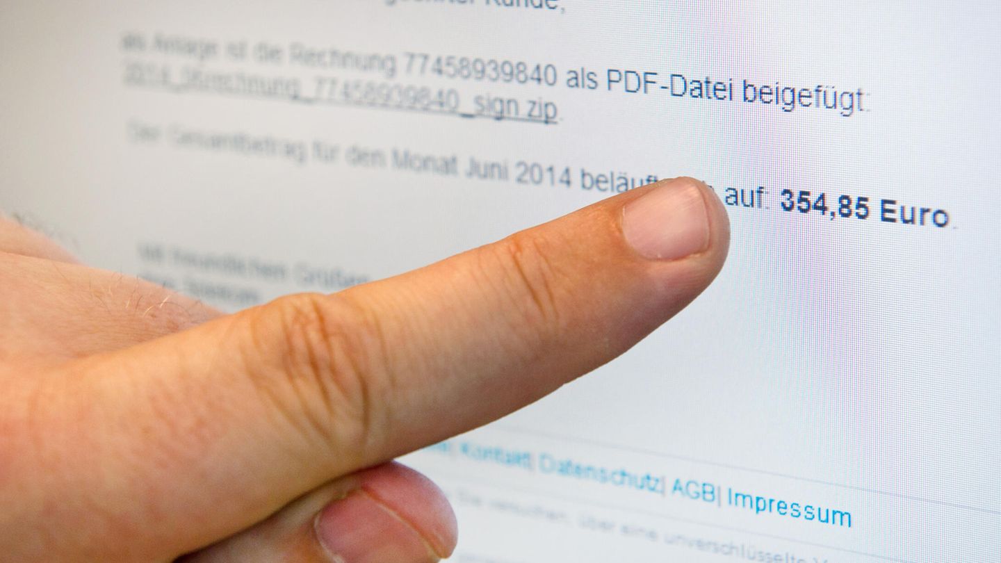 Ein Mann zeigt auf einen Monitor, auf dem eine gefälschte E-Mail der Telekom Deutschland GmbH angezeigt wird.