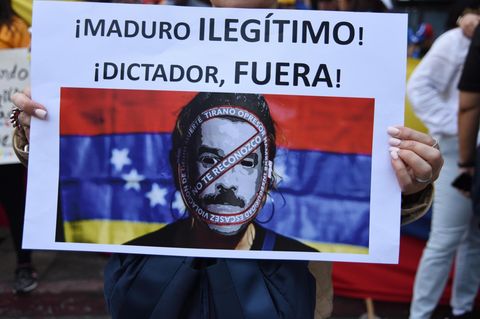 "Maduro, illegitimer Diktator, verschwinde", steht auf einem Plakat eines Demonstranten