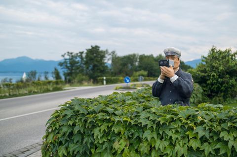 Ein Polizist aus Holz misst die Geschwindigkeit, doch die Straße ist komplett leer