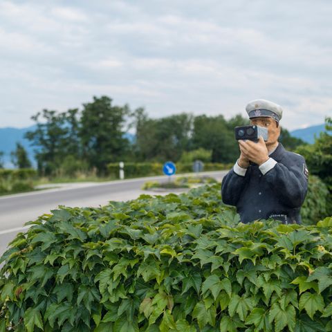 Ein Polizist aus Holz misst die Geschwindigkeit, doch die Straße ist komplett leer