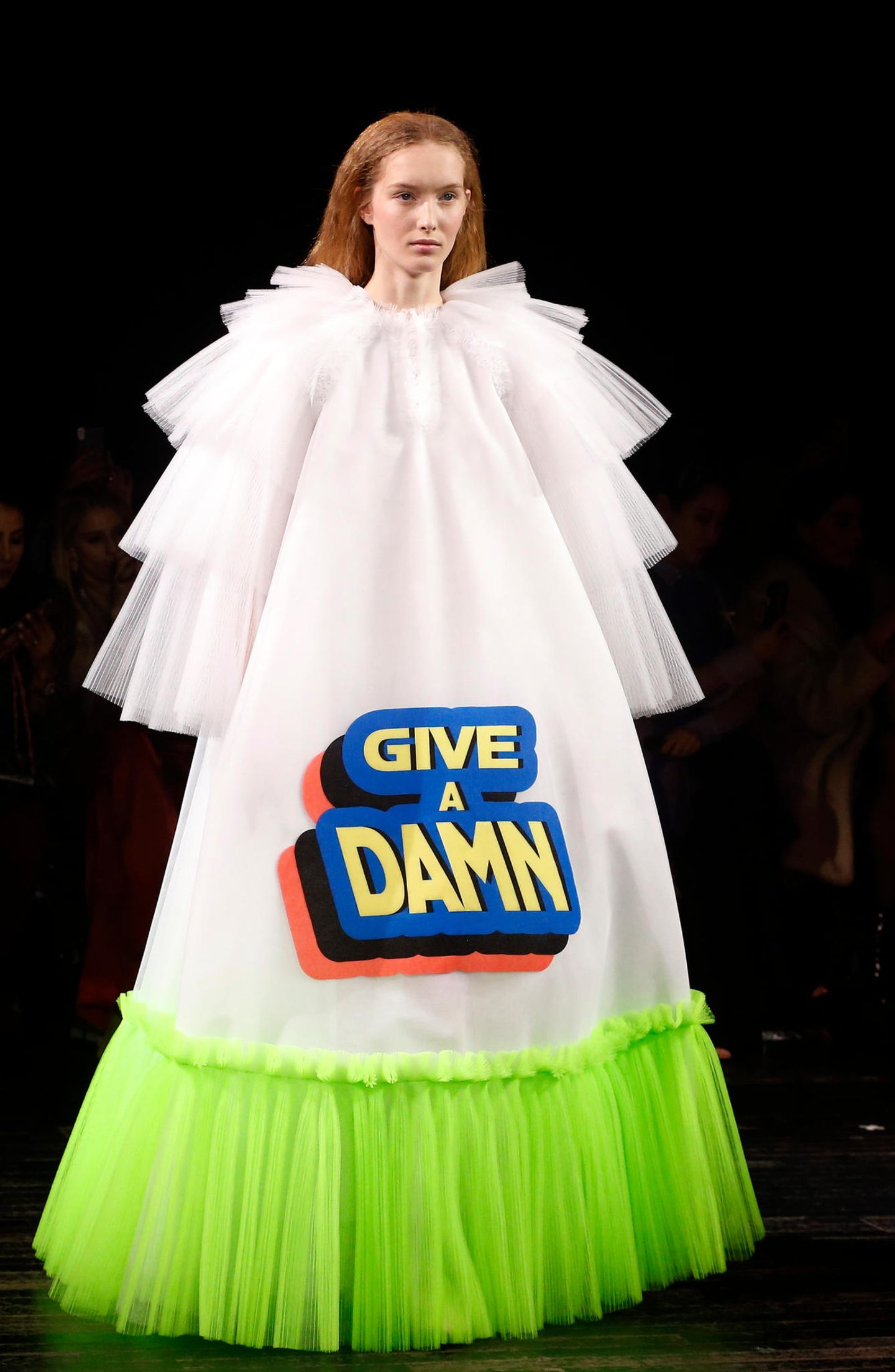 Paris Fashion Week: Wären wir nicht alle froh, diesen Schriftzug auf der Brust zu tragen und uns nicht durch langen Smalltalk quälen zu müssen? Ob es jetzt unbedingt das weiß-neon-farbene Tüllmonster sein muss, ist zu diskutieren.