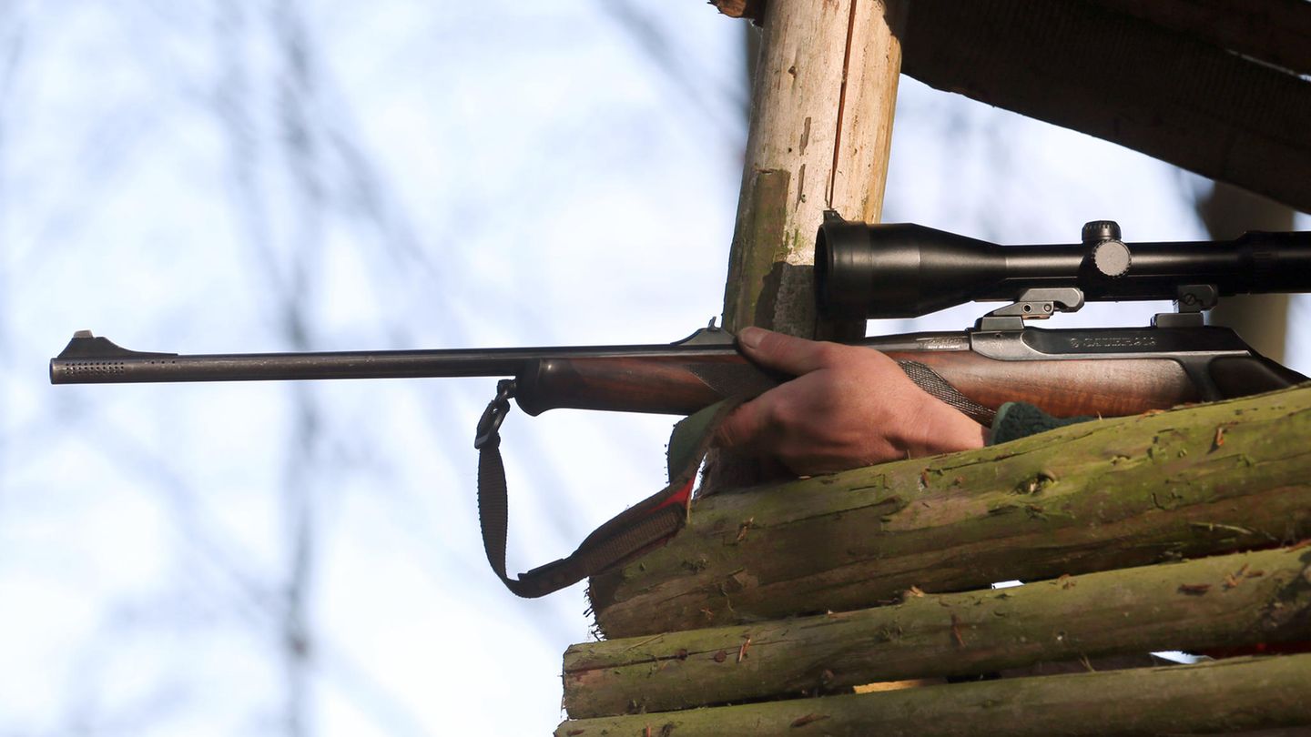 Ein Jäger hält sein Gewehr in einem Hochsitz