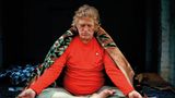 Ein älterer Mann meditiert im Schneidersitz