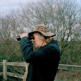 Ein älterer Mann schaut durch ein Fernglas