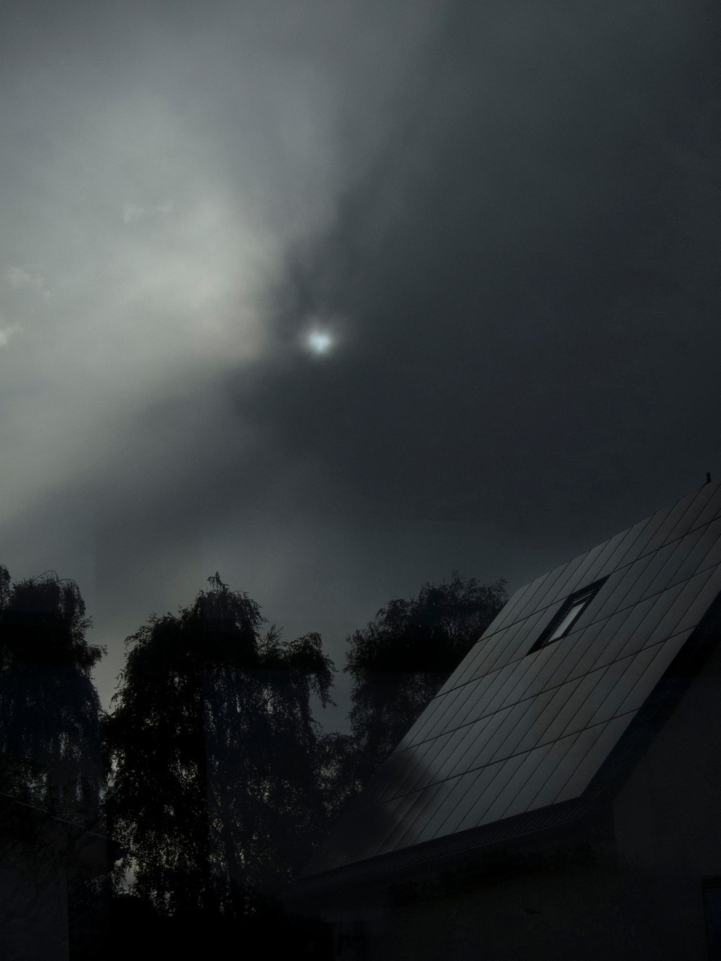 Vor die Sonne schieben sich schwarze Wolken