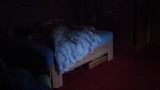 Ein Bett steht in einem abgedunkelten Zimmer