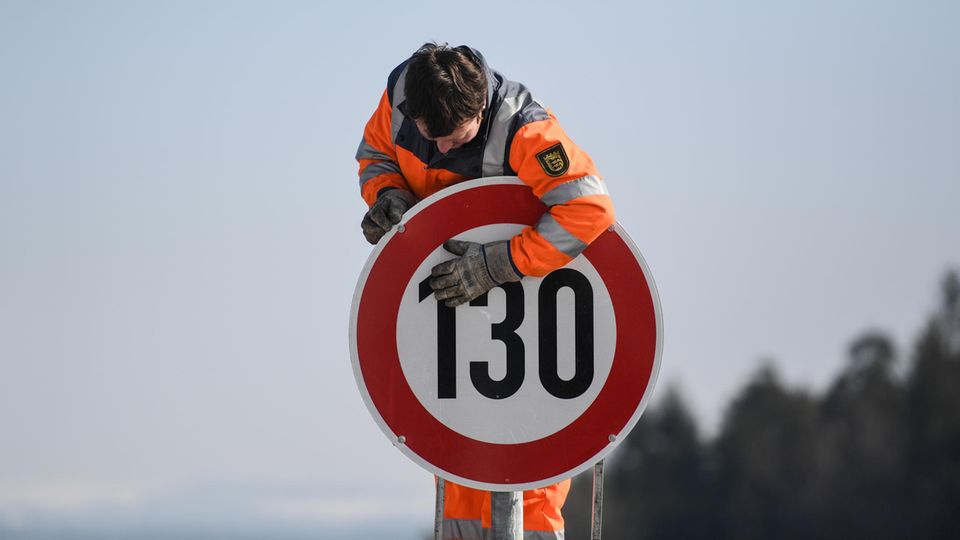 Ein Straßenwärter montiert an der Autobahn A81 am Hegaublick ein Schild mit der Aufschrift «130»