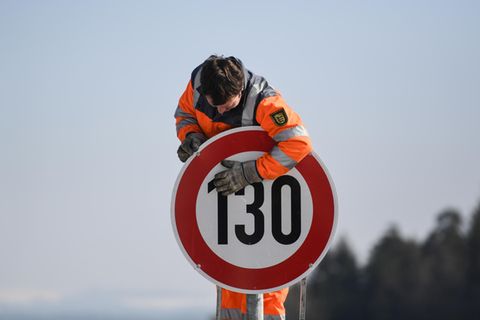 Ein Straßenwärter montiert an der Autobahn A81 am Hegaublick ein Schild mit der Aufschrift «130»