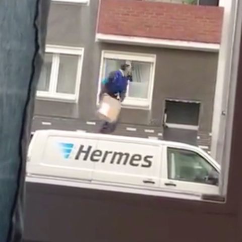 Ein Hermes-Bote wirft ein Paket auf den Balkon.