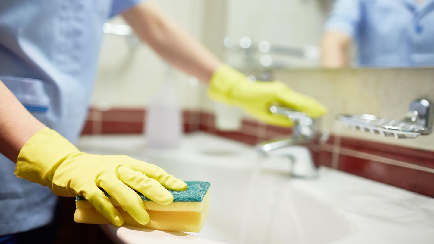 Eine Frau, die ein Waschbecken putzt