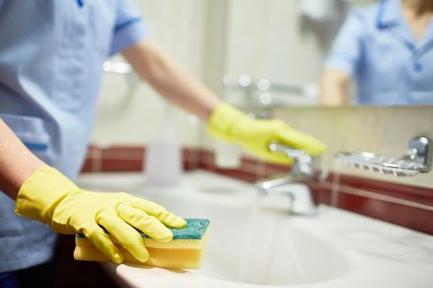 Eine Frau, die ein Waschbecken putzt