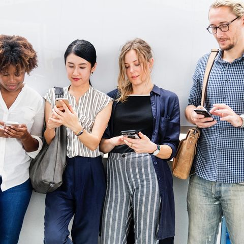 Fünf Menschen schauen auf ihr Smartphone