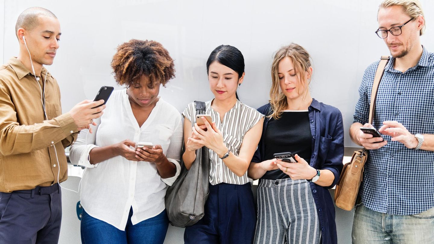 Fünf Menschen schauen auf ihr Smartphone
