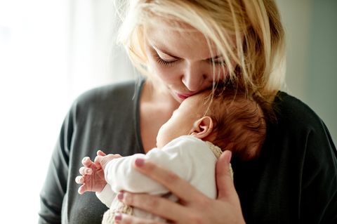 Herpes-Viren: Eine Frau küsst ein Neugeborenes auf die Stirn