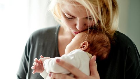 Herpes-Viren: Eine Frau küsst ein Neugeborenes auf die Stirn