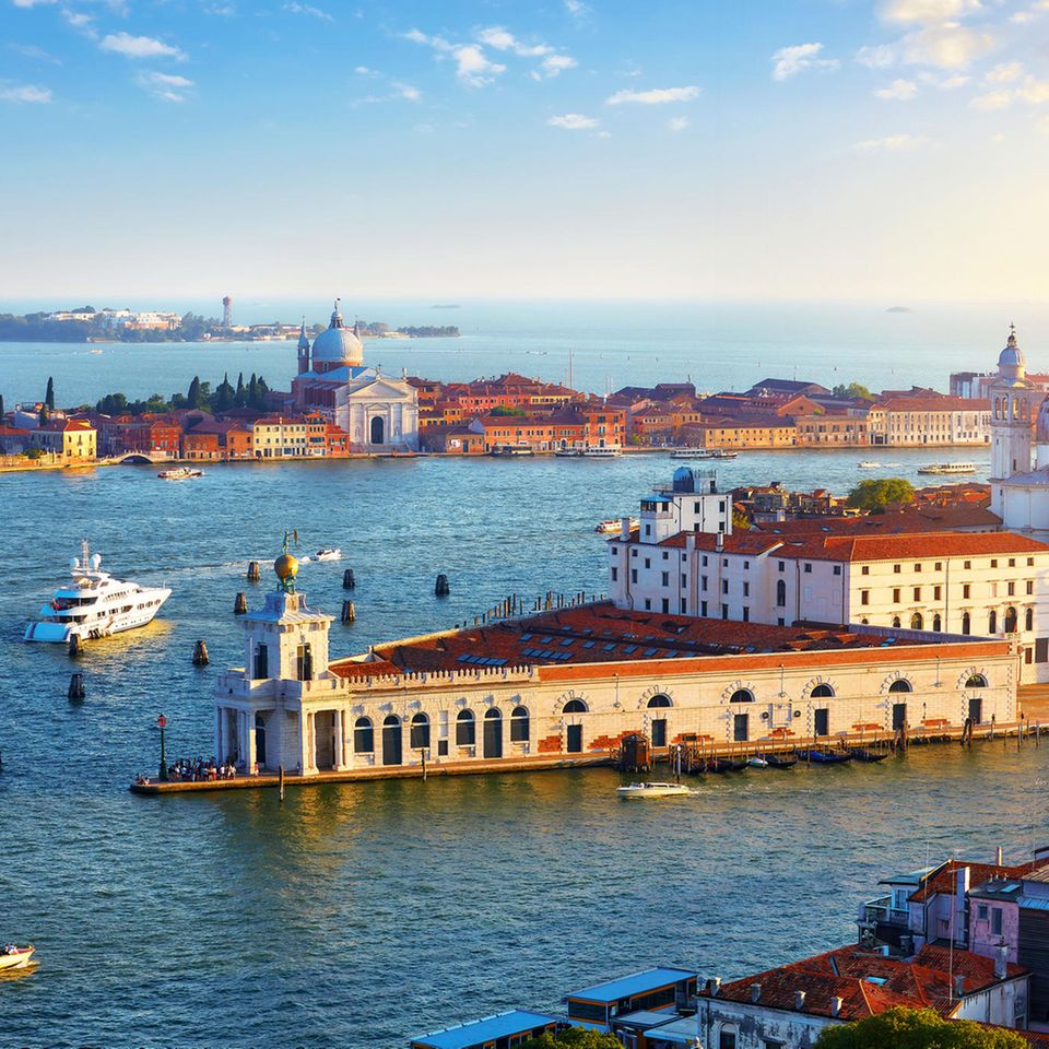 Italien: Venedig  Die Kreuzfahrtschiffe machen am Nordwestende der Lagunenstadt in der Nähe des Bahnhofs Santa Lucia fest. Zum Flughafen sollte man eine knappe Stunde mit dem Bus einplanen. Die Stadt lässt sich bestens zu Fuß und mit dem Wassertaxi erkunden. Die atemraubende Ein- und Ausfahrt durch den Giudecca-Kanal (Foto) bleibt großen Schiffen weiterhin gestattet, nachdem ein Verwaltungsgericht das Verbot gekippt hat.