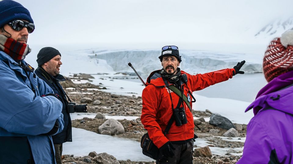 Rémis erklärt Gästen die Entstehung von Gletschern. Wie alle Guides ist auch er bei Landgängen bewaffnet, falls ein Eisbär auftauchen sollte.