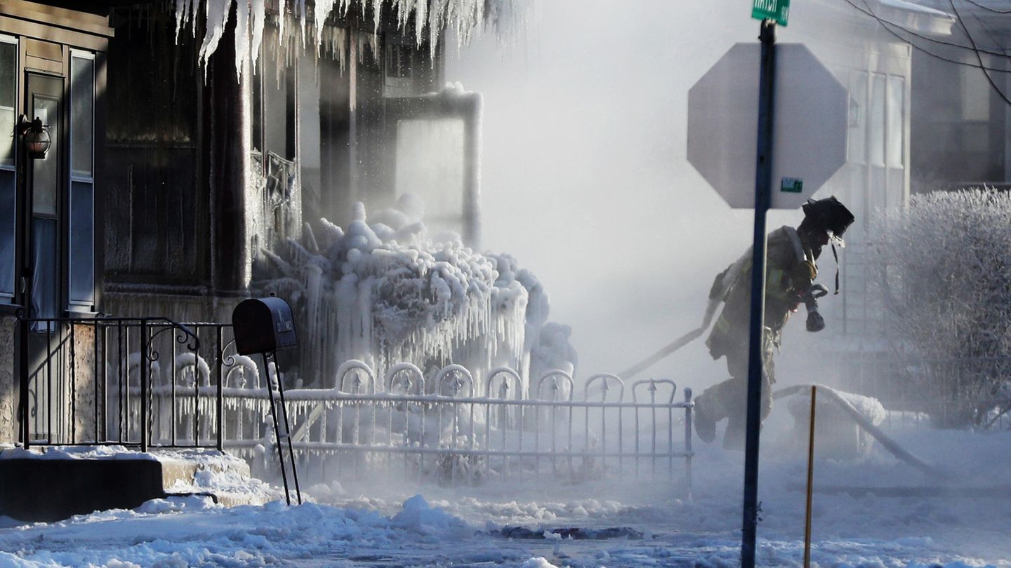 Ein Feuerwehrmann im Einsatz während eines Brandes in einem Wohnhaus in St. Paul. Das Löschwasser sorgt für die Entstehung von bizarren Eiszapfen.