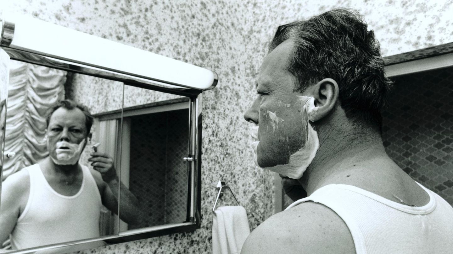 Willy Brandt 1969 während einer Wahlkampfreise vor dem Spiegel stehend und sich rasierend