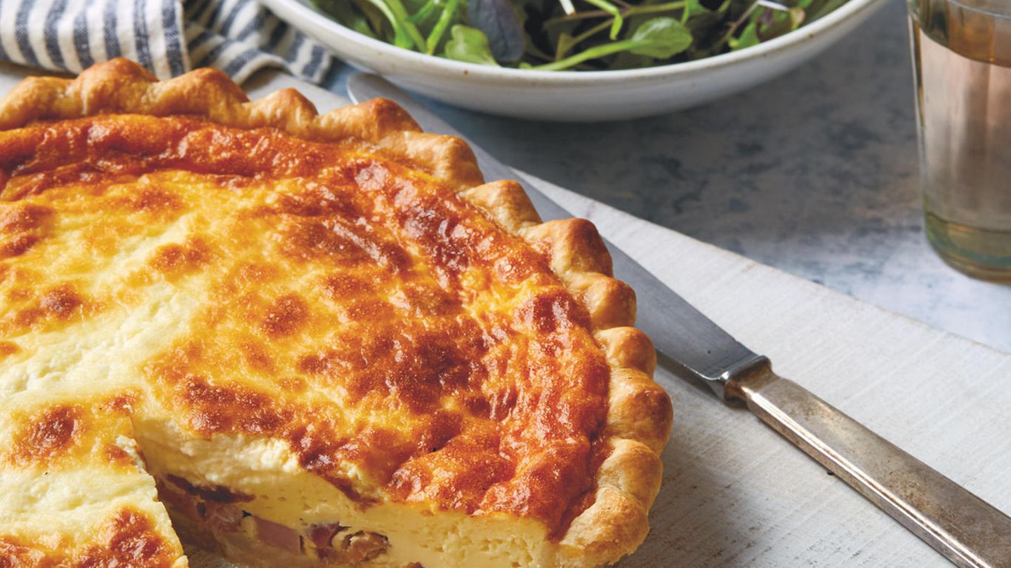La Cuisine de Paris: Quiche Lorraine Zutaten: Mürbeteig, 5 dicke Scheiben Speck (insgesamt 150 g), roh oder geräuchert, in kurze Streifen geschnitten, 4 große Eier, 180 g Crème fraîche, 360 ml Vollmilch, ⅛ TL frisch gemahlener schwarzer Pfeffer, ⅛ TL frisch gemahlene Muskatnuss, 55 g dicke Schinkenscheiben, gewürfelt Mürbeteig: 200 g Weizenmehl (Type 405), plus mehr zum Ausrollen, ½ TL feines Meersalz, 100 g kalte Butter, gewürfelt, 1 großes Ei, eiskaltes Wasser, wenn nötig Zubereitung: Den Mürbeteig zubereiten (oder kaufen) und eine Quiche- oder Tarte-Pfanne mit einem Durchmesser von 25 cm damit auskleiden. Den Backofen auf 200 °C vorheizen. Den Teig in der Quiche-Pfanne mit einem Backpapier abdecken und Backkugeln (oder getrocknete Bohnen) darauf verteilen. 15 Minuten blindbacken. In der Zwischenzeit in einer kleinen, trockenen Pfanne die Speckstreifen etwa 10 Minuten, oder bis sie leicht angebräunt sind, anbraten. Herausschöpfen. (Das ausgelassene Fett für andere Rezepte aufbewahren.) In einer mittelgroßen Schüssel die Eier mit einer Gabel vorsichtig verquirlen. Behutsam die Crème fraîche, die Milch, den Pfeffer und die Muskatnuss einrühren. Es sollte nicht zu viel Luft in die Mischung gerührt werden, sonst bilden sich Blasen in der Füllung, die beim Backen zu Rissen führen. Den Quicheboden aus dem Backofen holen und die Temperatur auf 150 °C reduzieren. Das Backpapier vorsichtig anheben und die Backkugeln entfernen. Den Speck und den Schinken gleichmäßig auf dem Quicheboden verteilen und dann langsam die Eiermischung darübergießen. Darauf achten, dass der Speck und der Schinken gleichmäßig verteilt bleiben. 50–60 Minuten, oder bis die Füllung goldbraun, aber in der Mitte noch ein wenig dickflüssig ist, backen. Vor dem Servieren mindestens 15 Minuten fest werden lassen. Warm oder zimmerwarm mit dem Salat genießen. Quiche Lorraine Zutaten: Mürbeteig, 5 dicke Scheiben Speck (insgesamt 150 g), roh oder geräuchert, in kurze Streifen geschnitten, 4 große Eier, 180 g Crème fraîche, 360 ml Vollmilch, ⅛ TL frisch gemahlener schwarzer Pfeffer, ⅛ TL frisch gemahlene Muskatnuss, 55 g dicke Schinkenscheiben, gewürfelt Mürbeteig: 200 g Weizenmehl (Type 405), plus mehr zum Ausrollen, ½ TL feines Meersalz, 100 g kalte Butter, gewürfelt, 1 großes Ei, eiskaltes Wasser, wenn nötig Zubereitung: Den Mürbeteig zubereiten (oder kaufen) und eine Quiche- oder Tarte-Pfanne mit einem Durchmesser von 25 cm damit auskleiden. Den Backofen auf 200 °C vorheizen. Den Teig in der Quiche-Pfanne mit einem Backpapier abdecken und Backkugeln (oder getrocknete Bohnen) darauf verteilen. 15 Minuten blindbacken. In der Zwischenzeit in einer kleinen, trockenen Pfanne die Speckstreifen etwa 10 Minuten, oder bis sie leicht angebräunt sind, anbraten. Herausschöpfen. (Das ausgelassene Fett für andere Rezepte aufbewahren.) In einer mittelgroßen Schüssel die Eier mit einer Gabel vorsichtig verquirlen. Behutsam die Crème fraîche, die Milch, den Pfeffer und die Muskatnuss einrühren. Es sollte nicht zu viel Luft in die Mischung gerührt werden, sonst bilden sich Blasen in der Füllung, die beim Backen zu Rissen führen. Den Quicheboden aus dem Backofen holen und die Temperatur auf 150 °C reduzieren. Das Backpapier vorsichtig anheben und die Backkugeln entfernen. Den Speck und den Schinken gleichmäßig auf dem Quicheboden verteilen und dann langsam die Eiermischung darübergießen. Darauf achten, dass der Speck und der Schinken gleichmäßig verteilt bleiben. 50–60 Minuten, oder bis die Füllung goldbraun, aber in der Mitte noch ein wenig dickflüssig ist, backen. Vor dem Servieren mindestens 15 Minuten fest werden lassen. Warm oder zimmerwarm mit dem Salat genießen.