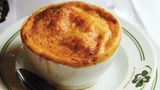 Pariser Zwiebelsuppe      Zutaten:  15 g Butter, 1 EL Olivenöl, 560 g gelbe Zwiebeln, fein geschnitten, 1 TL feines Meersalz, 2 EL Weizenmehl, Type 405, 120 ml trockener Weißwein (alternativ Bier oder halb Portwein, halb Wasser), 960 ml Rinderbrühe, vorzugsweise selbst gemacht, 1 EL Rotweinessig, 4 Scheiben Brot mit Kruste (ca. 1,25 cm dick), auf die Größe der Suppenschüssel zugeschnitten, 150 g frisch geriebener Käse, wie Comté oder Gruyère, frisch gemahlener schwarzer Pfeffer, frisch gemahlene Muskatnuss      Zubereitung:  In einem Topf mit schwerem Boden bei mittlerer Temperatur die Butter und das Öl erhitzen. Die Zwiebeln und das Salz dazugeben und verrühren. Unter Rühren 30–35 Minuten, oder bis die Zwiebeln stark karamellisiert sind, kochen. Wenn sie am Boden haften bleiben, 1 EL Wasser dazugeben und die am Boden haftenden Stücke abschaben. Das Mehl einrühren. Den Wein und die Brühe hinzugeben, den Boden des Topfes abschaben und zum Köcheln bringen. Den Topf abdecken und die Suppe 15 Minuten kochen. Den Essig einrühren, die Suppe probieren und abschmecken. (Die Suppe kann bis zu einem Tag im Voraus zubereitet werden.) Auskühlen lassen, abdecken und kalt stellen. Vor dem Weiterverarbeiten aufwärmen.      Den Grill vorheizen.      Die Suppe auf 4 Schüsseln verteilen. Die Schüsseln auf ein tiefes Backblech stellen. In jede Schüssel ein Stück Brot legen und mit je 6 EL Käse bestreuen. Unter den Grill stellen und im Auge behalten. 4–5 Minuten, oder bis der Käse goldgelb ist und brodelt, grillen. Mit dem schwarzen Pfeffer und der Muskatnuss würzen.      Die Schüsseln auf einen hitzebeständigen Teller stellen und servieren. Die Gäste warnen, dass die Schüsseln heiß sind.