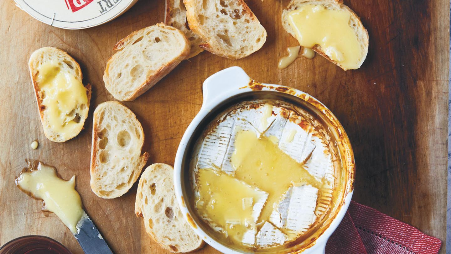 Gebackener Camembert mit Honig & Cidre      Zutaten:  220–250 g Camembertkäse, 1 EL Cidre oder Apfelweinbrand, z. B. Calvados, 2 TL Honig, frisches Baguette zum Servieren      Zubereitung:  Den Käse 1 Stunde im Voraus aus dem Kühlschrank holen. Aus der Verpackung nehmen und jegliche Aufkleber oder Etiketten entfernen. Den Käse in eine ofenfeste Schüssel oder Backform, die weder zu groß noch zu klein ist, geben. Den Backofen auf 200 °C vorheizen. Mit einem scharfen Messer den Camembert in einem Rautenmuster tief einritzen. Mit dem Cidre beträufeln und den Honig darauflöffeln. 15–20 Minuten, oder bis der Käse geschmolzen und angebräunt ist, backen. 5 Minuten ruhen lassen und dann mit dem Brot servieren.
